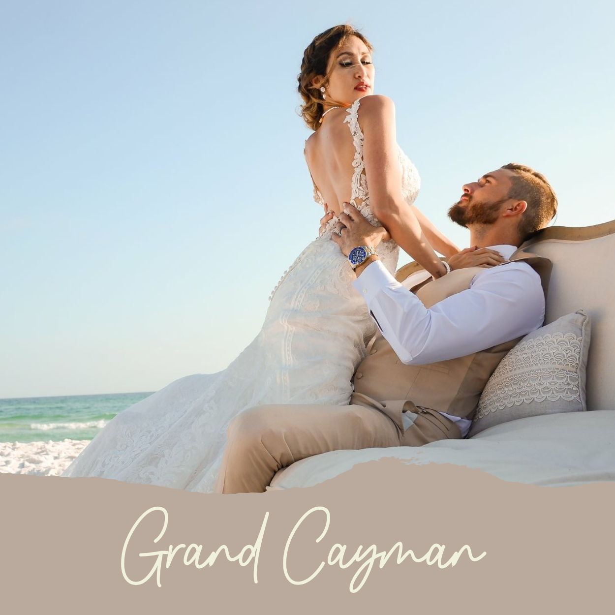 A groom looking longingly at his bride as they embrace on a cream vintage sofa at their destination wedding in Grand Cayman